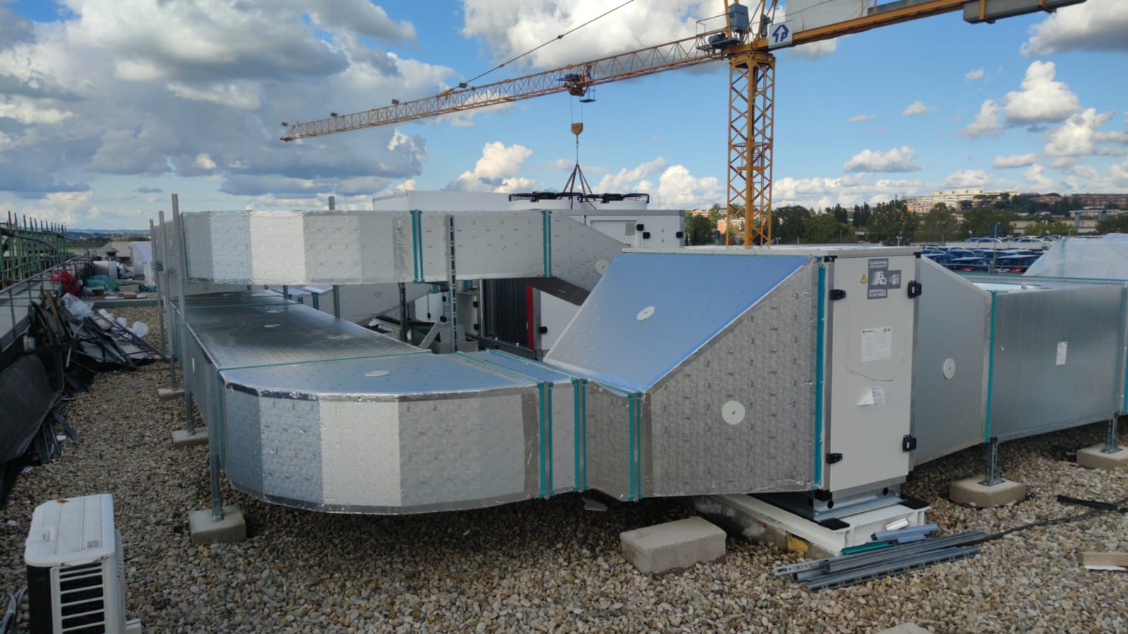 Impianto di climatizzazione con canalizzazioni isolate e unità di trattamento aria installati su una copertura industriale